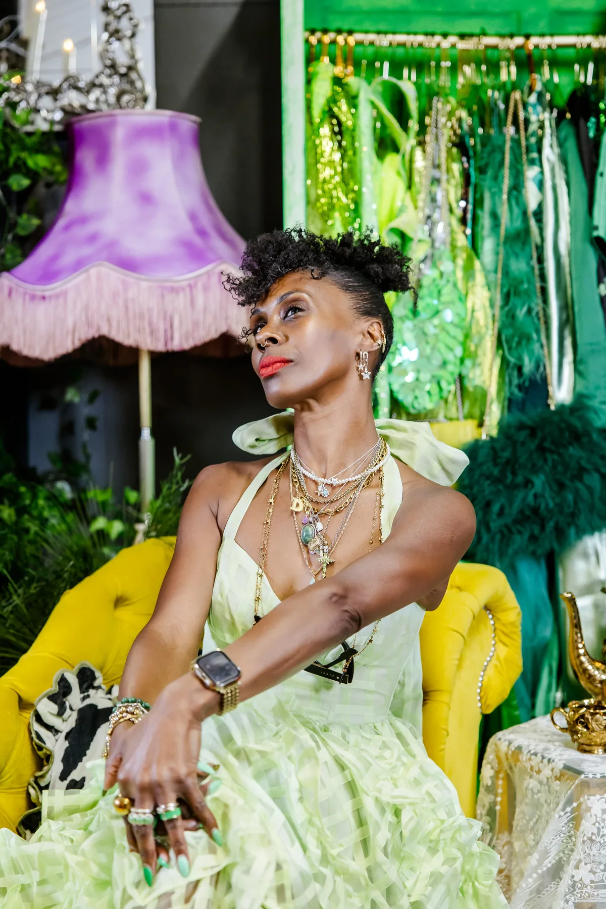 Deborah Dedewo, founder of The House of Fabulous, seated on the yellow chaise